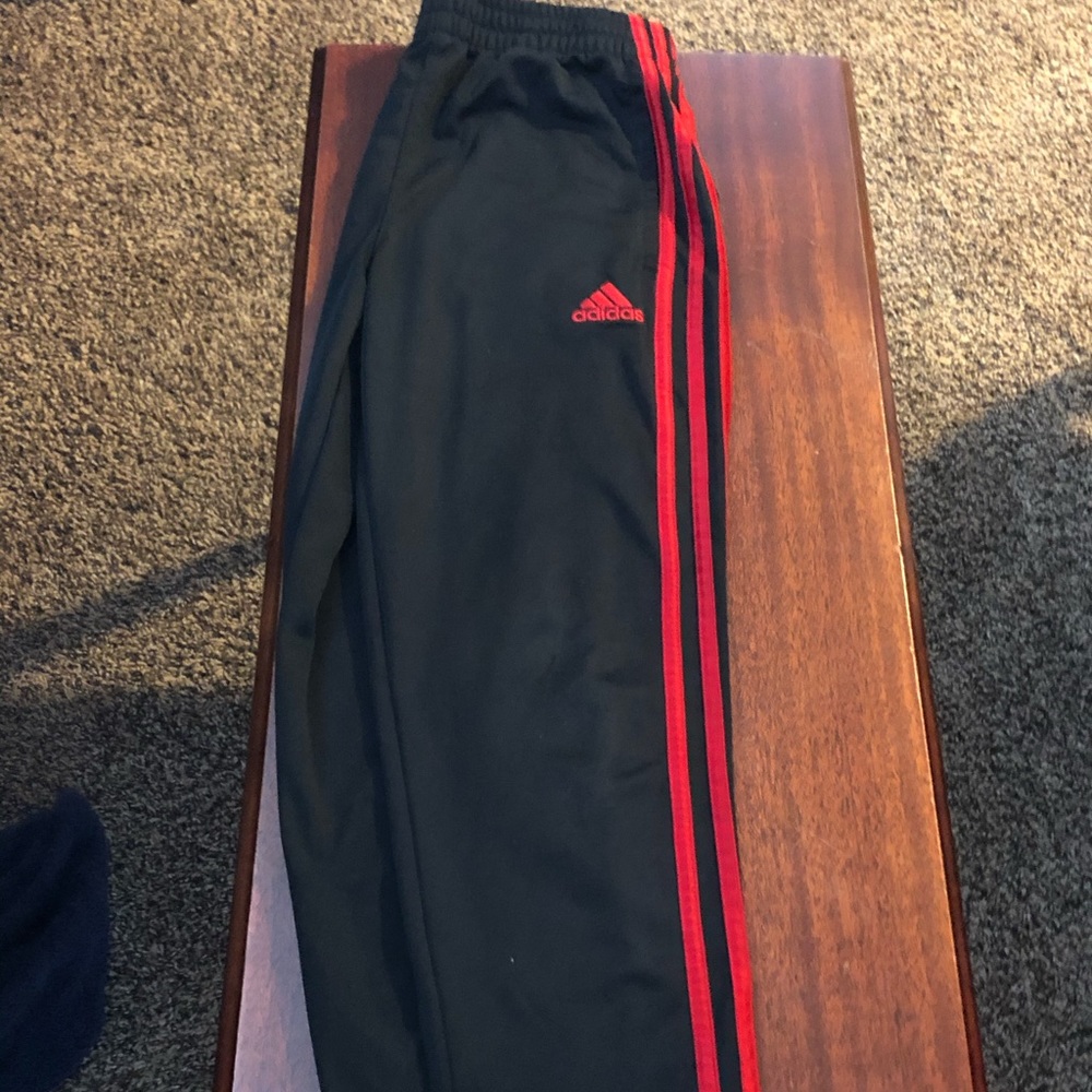Red stripe adidas joggers.